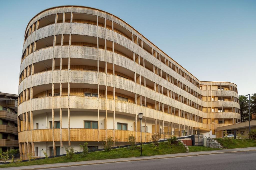 Hotel Caro & Selig in Tegernsee von außen, ein geschwungenes Gebäude mit vielen Holzelementen.